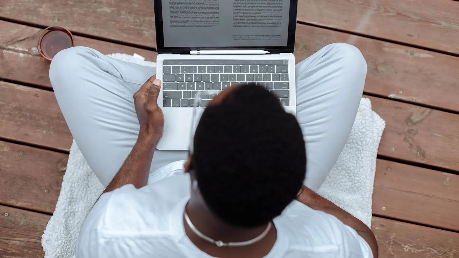 Contractor reviewing agency websites on a laptop while sitting on a wood deck