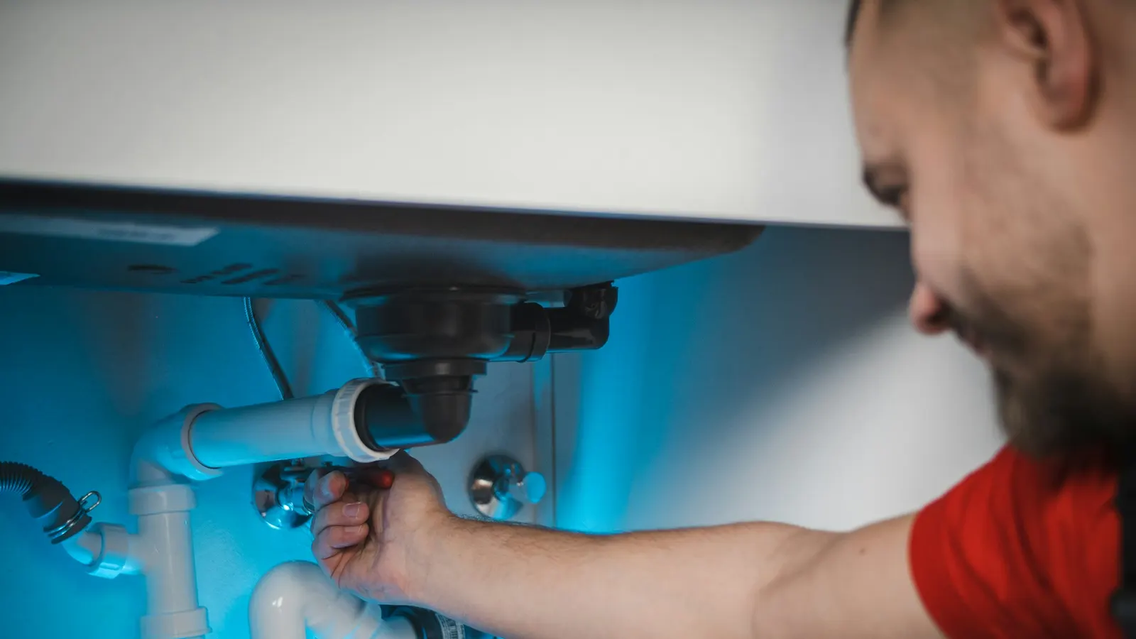 Plumber repairing a pipe inside an open wall cavity