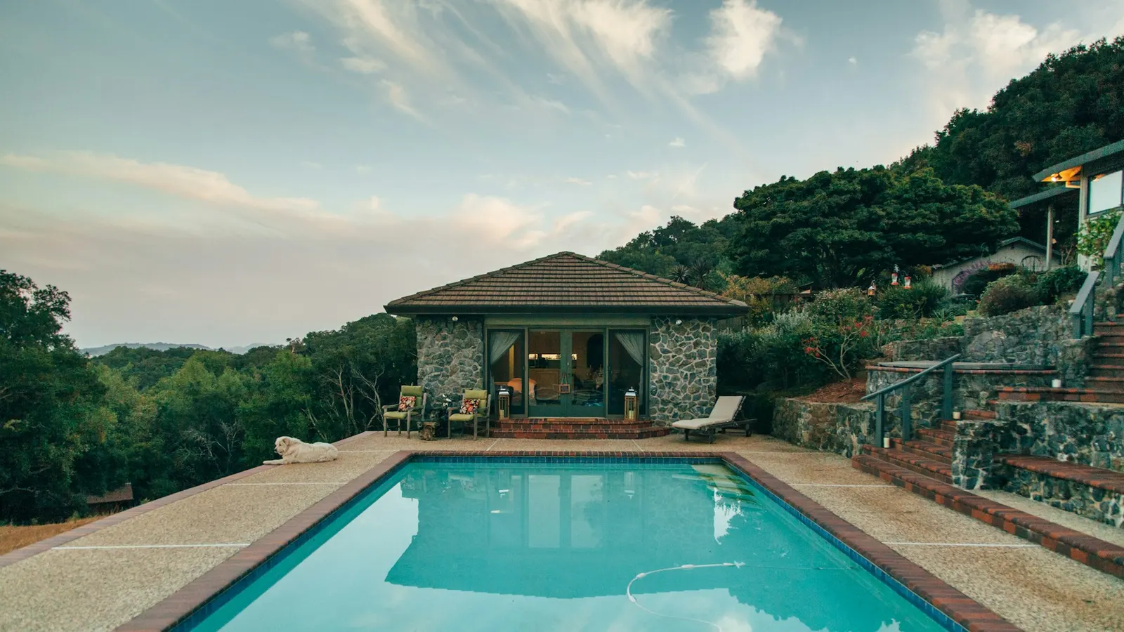 Stone pool house with an in-ground swimming pool