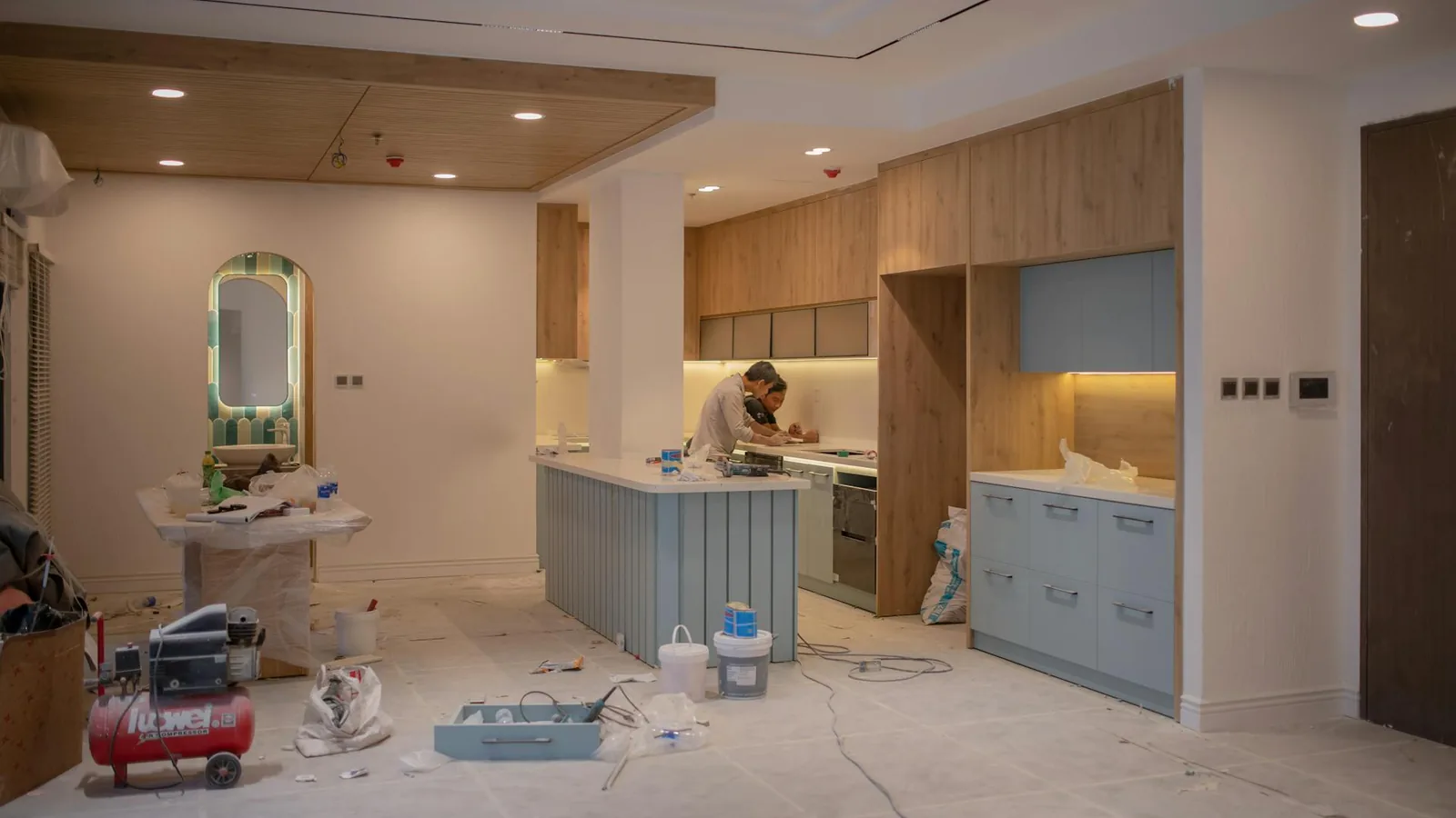 Remodeler reviewing a kitchen project gallery on a tablet in a finished kitchen