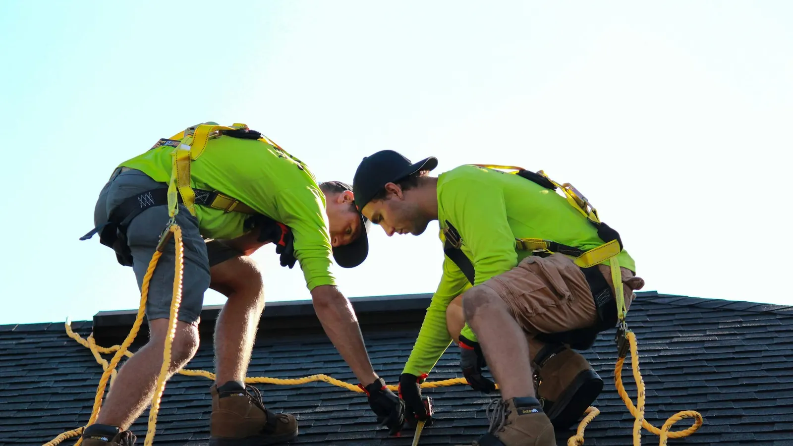 Installers mounting solar panels on a residential roof