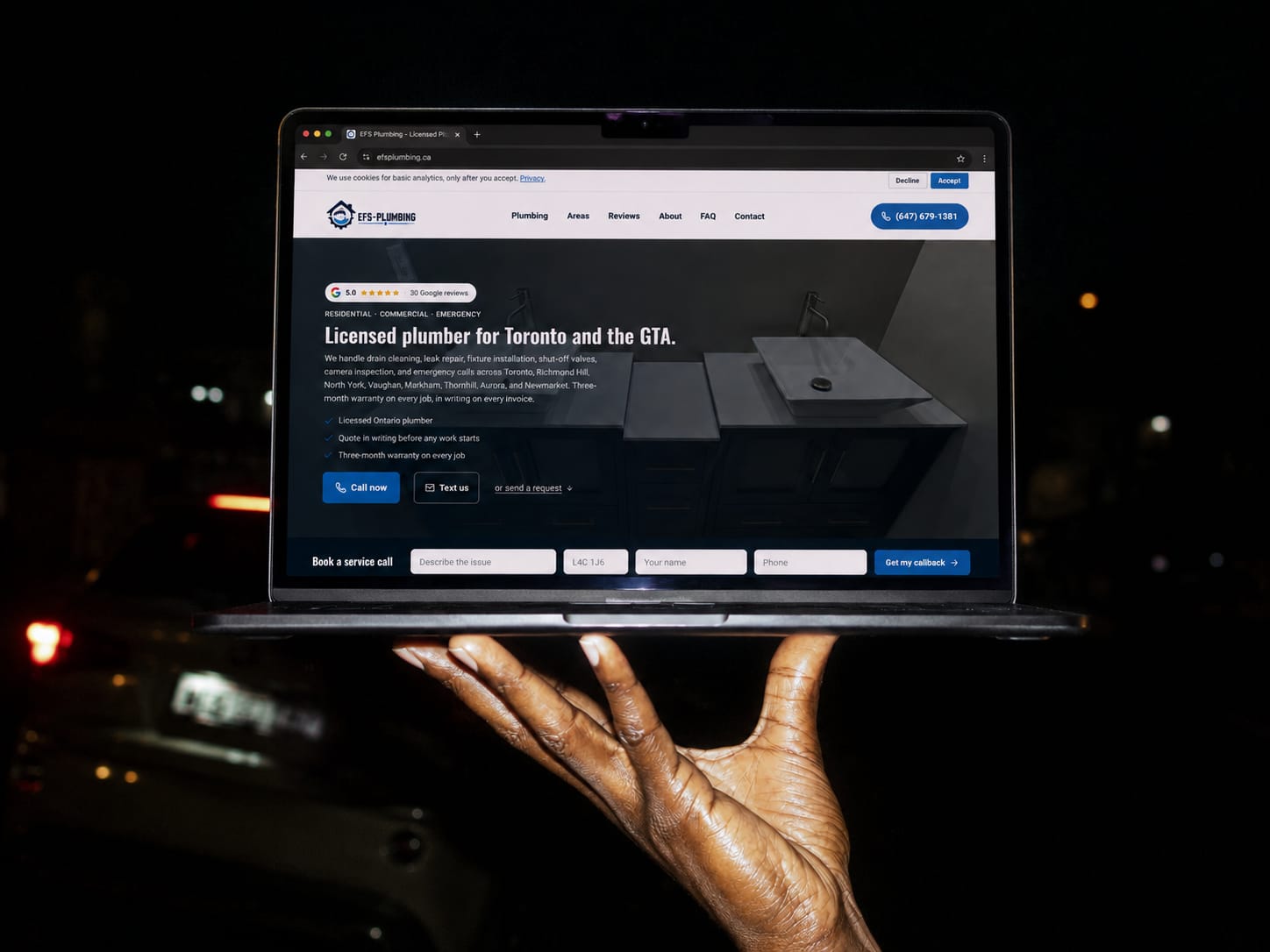 The EFS Plumbing website Fervor built, shown on a MacBook held at night against a dark background.