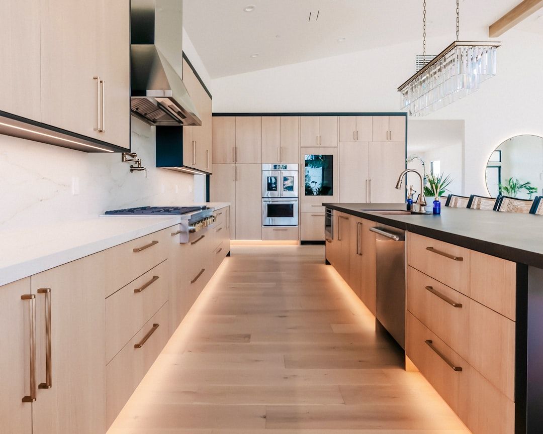 Modern kitchen with light wood cabinets and island.