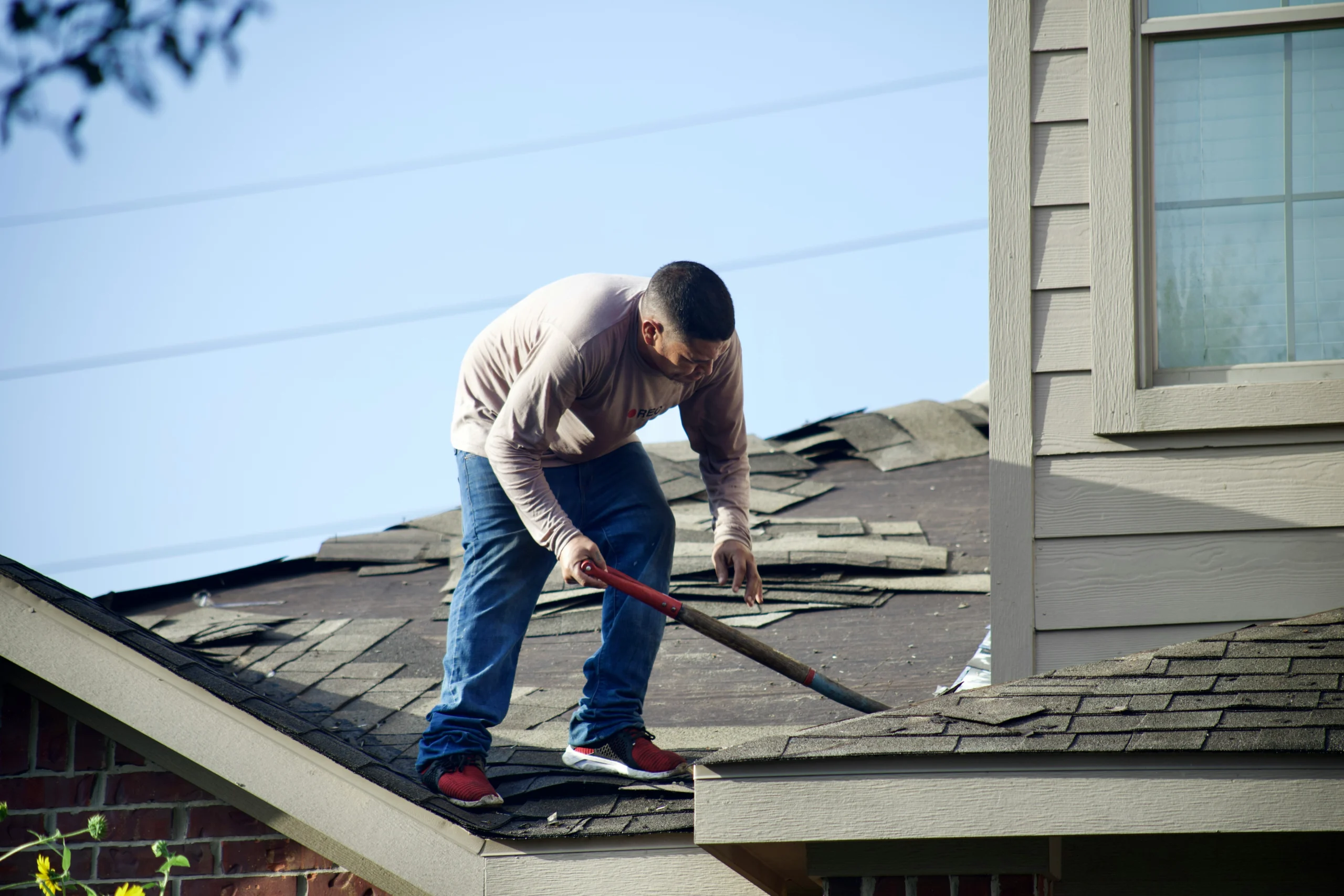 Roofer removing shingles